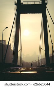 Photo In Summer Blockbuster Look Of City Landscape With A Lonely Man Walking Through An Empty Bridge.