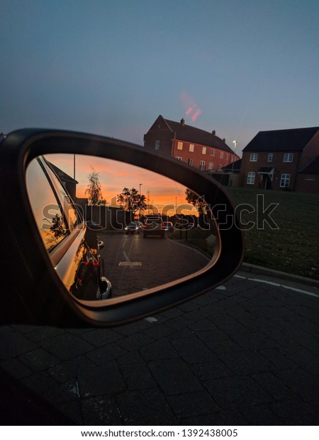 Photo of the sunset in a\
car mirror 