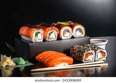Photo of sushi menu, rolls, Japanese cuisine isolated on a black background with elements of hands, Chinese chopsticks
