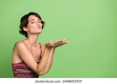 Photo of sweet adorable girl wear trendy spring clothes closed eyes kiss hold empty space isolated on green color background - Powered by Shutterstock