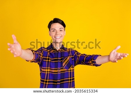 Photo of sweet brunet young guy want hug wear plaid shirt isolated on yellow color background