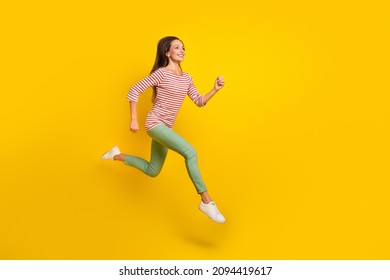 Photo Of Sweet Charming Mature Lady Dressed Striped Shirt Running Fast Jumping High Empty Space Smiling Isolated Yellow Color Background