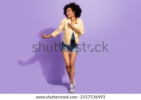 Photo of sweet charming woman dressed yellow jeans jacket smiling dancing isolated purple color background