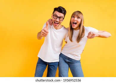 Photo of sweet charming young couple wear white t-shirt spectacles dancing showing thumb up isolated yellow color background - Shutterstock ID 1936952536