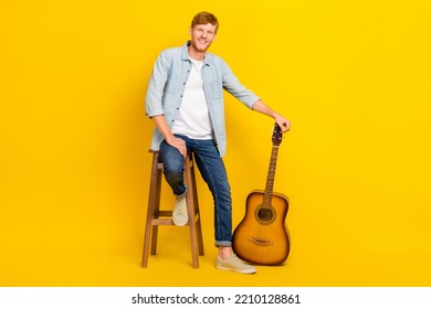 Photo of sweet cute guy dressed denim shirt playing guitar sitting chair empty space isolated yellow color background - Powered by Shutterstock