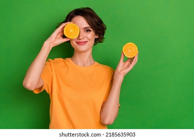 Photo of sweet cute young woman dressed orange t-shirt holding citrus slices cover eye empty space isolated green color background - Powered by Shutterstock