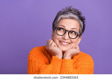 Photo of sweet dreamy lady wear knitted pullover spectacles arms cheeks looking empty space isolated purple color background