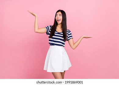 Photo Of Sweet Excited Lady Dressed Striped Clothes Smiling Compare Two Things Looking Empty Space Isolated Pink Color Background