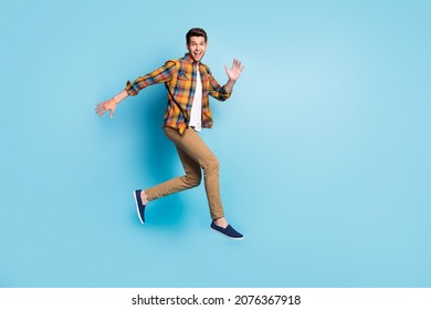 Photo of sweet excited young guy dressed plaid shirt spectacles smiling jumping high isolated blue color background - Powered by Shutterstock