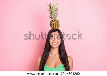Photo of sweet fooling young lady wear green tank-top smiling holding head looking fruit isolated pink color background