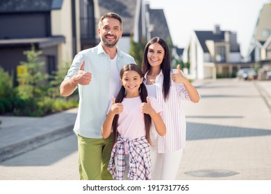 Photo of sweet optimistic family show approve sign walk near home wear casual cloth outside - Powered by Shutterstock