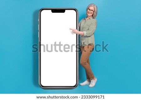Photo of sweet pretty mature girl teacher wear green shirt spectacles pointing modern gadget empty space isolated blue color background