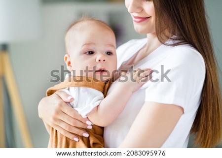Photo of sweet pretty mother holding arms hands child smiling inside indoors apartment room