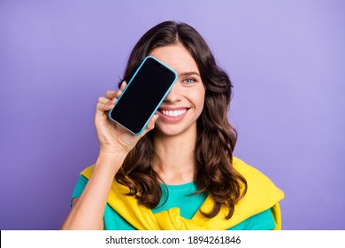 Photo of sweet pretty wavy young woman dressed pullover shoulders modern gadget cover eye isolated purple color background - Shutterstock ID 1894261846