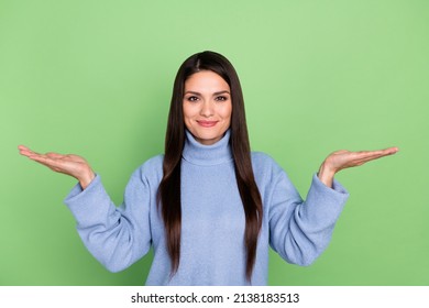 Photo of sweet shiny mature lady dressed blue pullover comparing arms empty space smiling isolated green color background