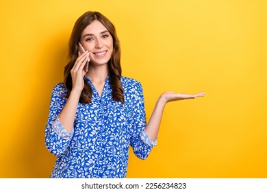Photo of sweet shiny woman dressed blue blouse talking modern gadget holding arm empty space isolated yellow color background - Shutterstock ID 2256234823
