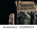 Photo of tactical military soldier armored vest with pouches close-up view on dark background.