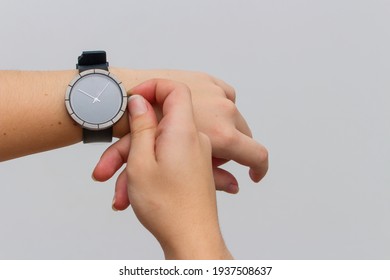 
photo taken on white background, in studio, of female arm with black watch