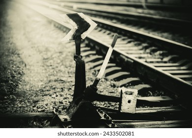 A photo taken with a sepia filter shows a retro-style mechanism on a railway, which turns the rails.