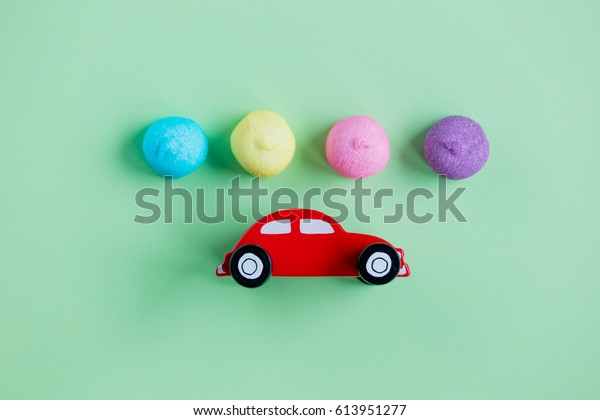 photo of tasty marshmallows and car shaped toy\
on the wonderful green\
background