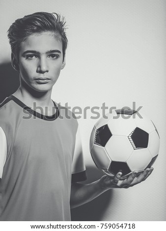 Photo of teen boy in sportswear holding soccer ball - posing at studio