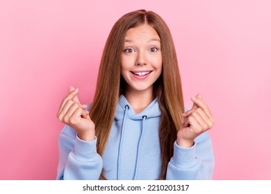 Photo Of Teen Funny Optimistic Cute Girl School Learner Wear Blue Sweater Excited Face Showing Korean Heart Symbol Isolated On Pink Color Background