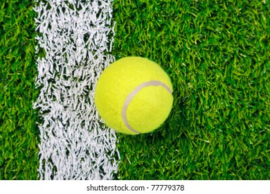 Photo Of A Tennis Ball On A Grass Next To The White Line, Shot From Above.