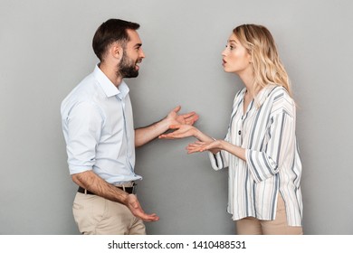 Photo Of Tense Couple In Casual Clothes Discussing Problems And Arguing Isolated Over Gray Background