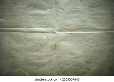 Photo of the texture of an old darkened sheet of paper. Vintage manuscript. A blank sheet of an ancient manuscript. An old battered background for a photo. - Shutterstock ID 2165557645