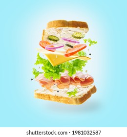 In the photo there is a sandwich with different products, vegetables, cheese, meat, lettuce, onions. Pale blue background. Pastel shades. No people. Levitation.