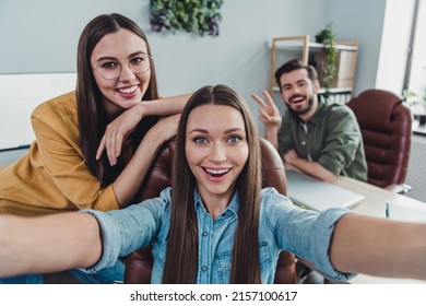 Photo of three business partners take selfie hand demonstrate v-sign meeting workstation indoors