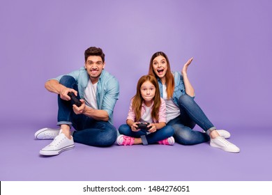 Photo of three family members sitting floor trying hard to win team game wear casual clothes isolated purple background - Powered by Shutterstock