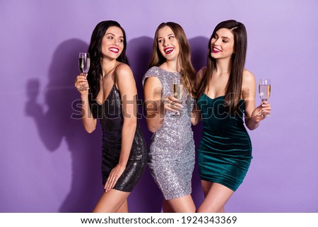 Photo of three luxury ladies hold glasses enjoy drink sparkling wine wear mini dresses isolated purple color background