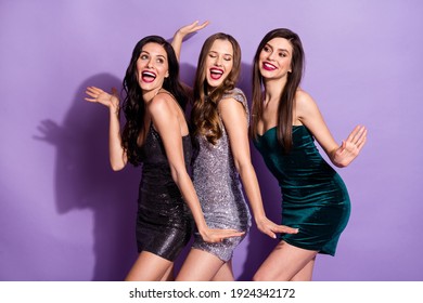 Photo of three pretty ladies dance raise palms open mouth have fun wear mini dresses isolated purple color background