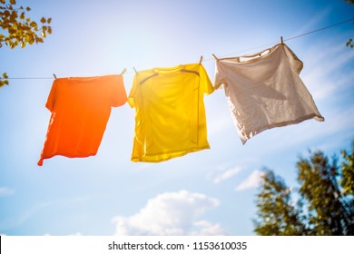 Photo of three T-shirts hanging on rope against blue sky background - Powered by Shutterstock