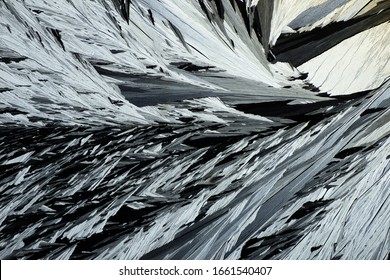 Photo Through A Microscope Of Crystals Growing From The Melt Of Ammonia Alum. Polarized Light Technology. Abstract Art Wallpaper. Background For Design.