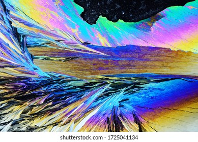 Photo Through A Microscope Of Crystals Growing From The Melt Of Ammonia Alum. Polarized Light Technology. Abstract Art Wallpaper. Background For Design.