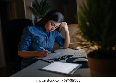 Photo Of A Tired Woman Working At Home Late At Night.