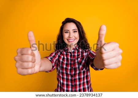 Photo of toothy beaming woman with wavy hairdo dressed checkered shirt showing thumbs up to you good job isolated on yellow background