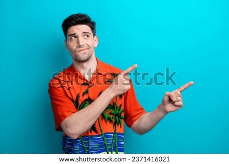 Photo of tourist young guy summer holiday vacation indicating new promo video decide which country visit isolated on blue color background