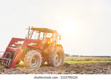 Photo of tractor in field with lens flare in background - Shutterstock ID 1515790124