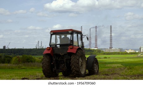 Photo of tractor and industrial factory in the field