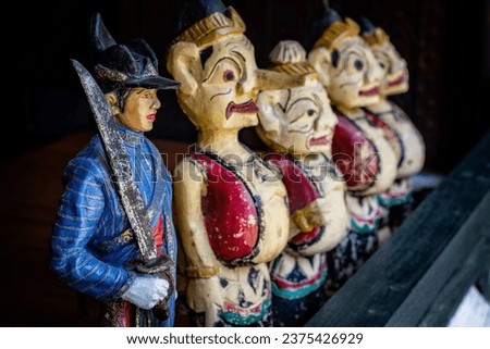A photo of a traditional army figure, accompanied by figures of Punakawan (Javanese puppet figures)