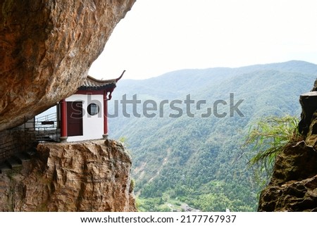 Photo of a traditional Chinese style house on the edge of a cliff in the mountains, Zhejiang Province, China