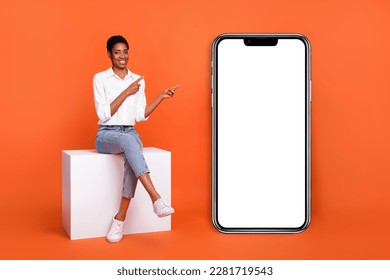 Photo of trans woman sit podium point finger empty blank copy space promote product isolated on orange color background - Powered by Shutterstock
