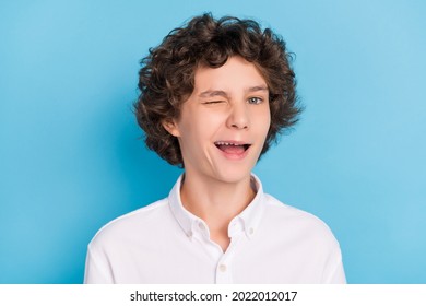 Photo of tricky pretty schoolboy wear white shirt smiling winking isolated blue color background