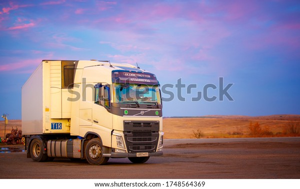 Photo of a truck, a car\
with a towed refrigerator against the sunset sky, 2019-10-13 Russia\
Rostov Region