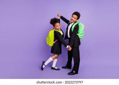 Photo Of Two African People Schoolchildren Dance Hold Hands Wear Rucksack Uniform Isolated Violet Color Background