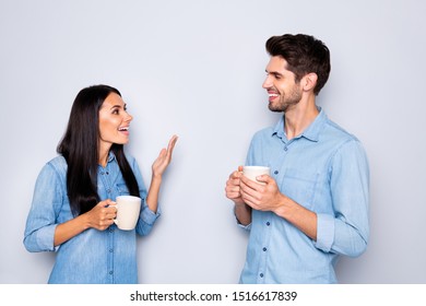 Photo of two amazing colleagues working together spend coffee break chatting holding hot beverage wear casual jeans clothes isolated grey color background