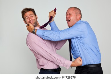 Photo Of Two Businessmen Fighting Against A Plain Background, Part Of A Series See My Portfolio For Them Shaking Hands And Hugging.